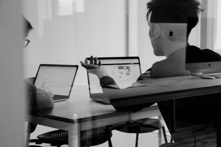 Professionals review a digital workflow showing automated data entry and AI document analysis on computer screens.